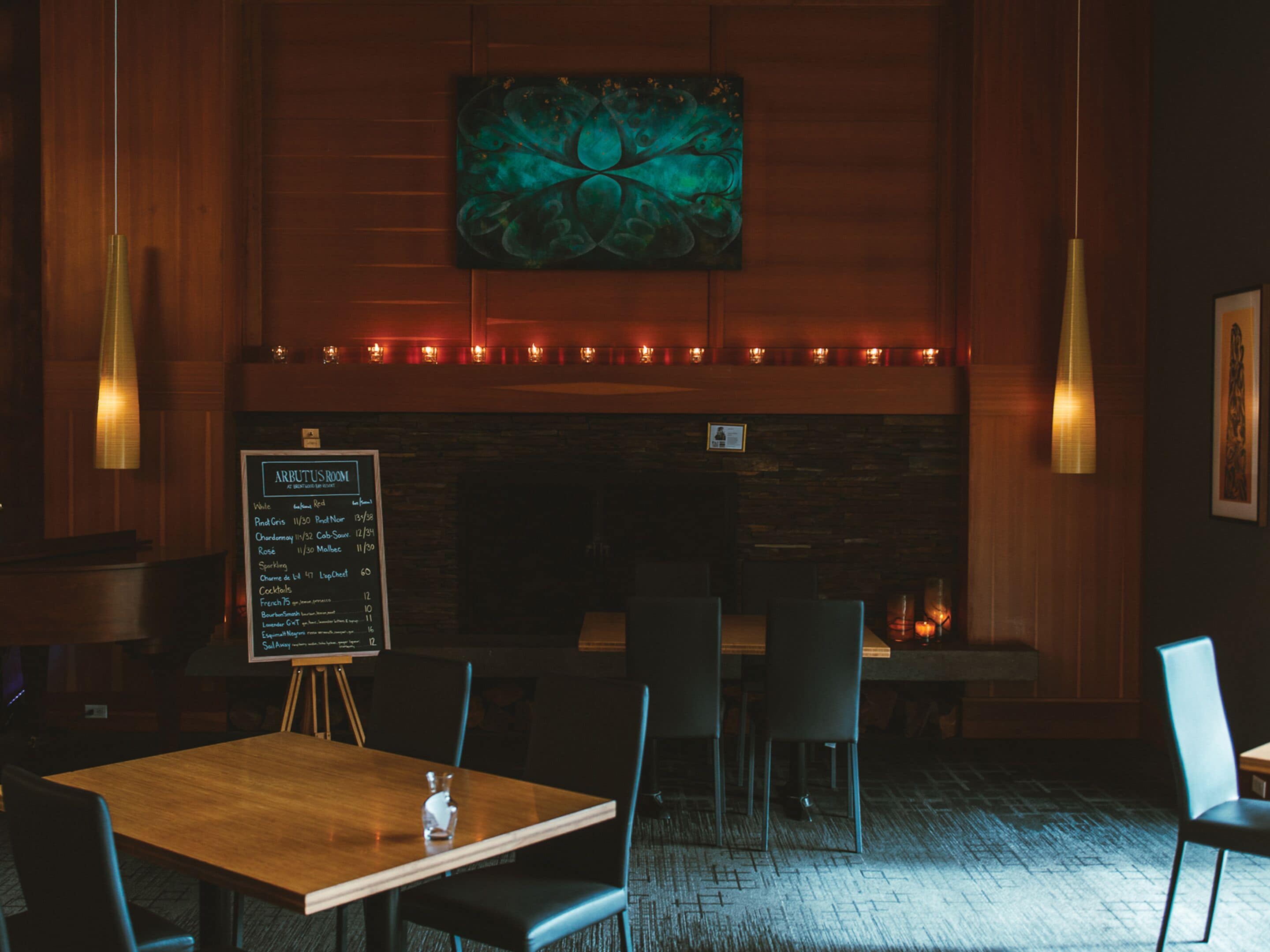 A restaurant with a wooden interior, a chalkboard menu, and pendant lighting.