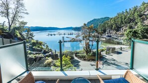 A balcony with a view of a lake, docked boats, and a forested hillside. - Poets Cove Resort & Spa (Pender Island)