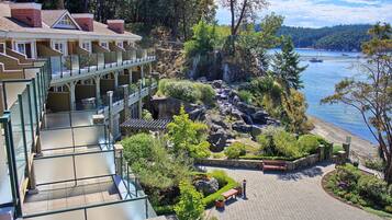Ein Hotel mit schöner Aussicht auf einen See, einem Felsengarten und einer Holzterrasse.