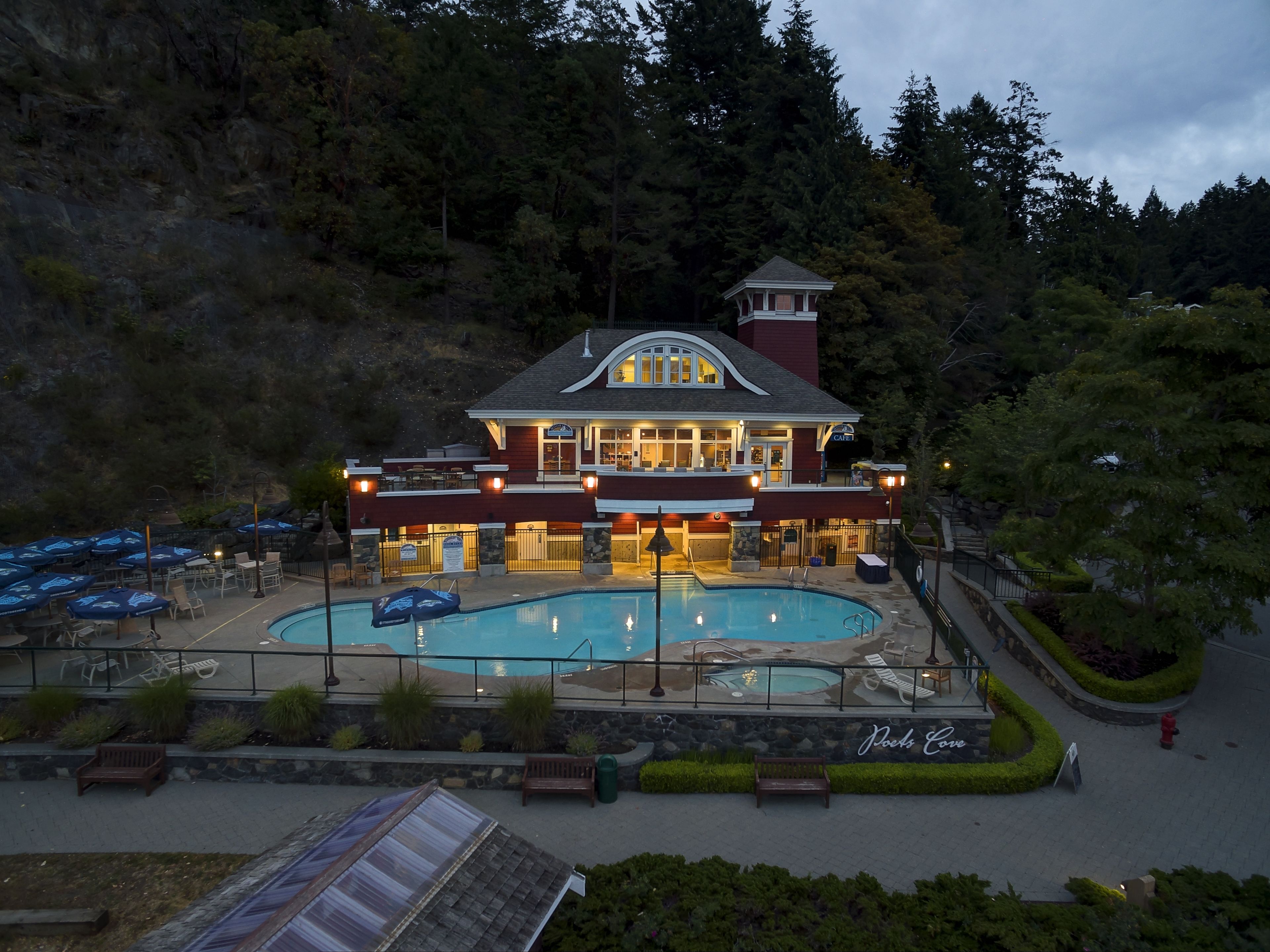 A hotel with a pool, outdoor seating, and a restaurant.