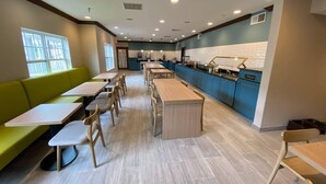 A modern restaurant with a long counter, booths, and a trash bin. - Country Inn & Suites by Radisson, Champaign North, IL (Champaign)