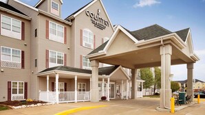 A Country Inn & Suites building with a covered entrance and a patio area. - Country Inn & Suites by Radisson, Champaign North, IL (Champaign)