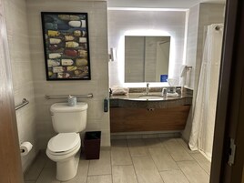 Un baño con inodoro, lavamanos y cortina de ducha.
