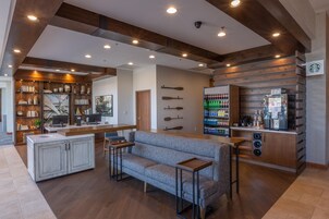 Un interior moderno con una zona de bar, asientos y una cocina.