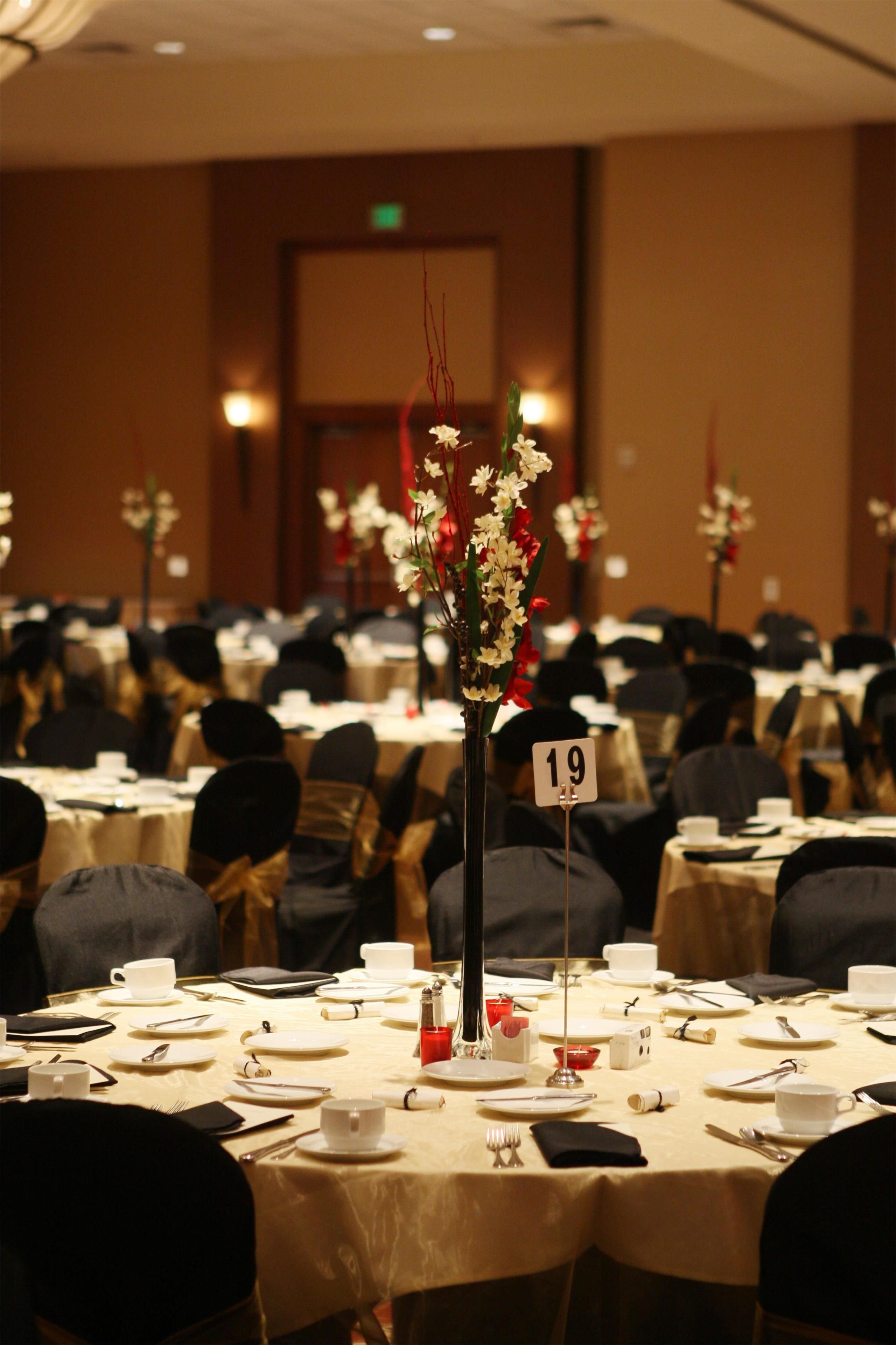 A conference room with tables set for a meeting, numbered signs, and floral centerpieces.