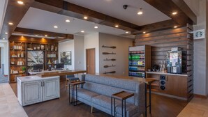 A modern interior with a bar area, seating, and a coffee machine.