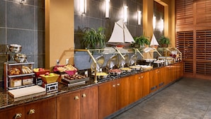 A buffet with various food items and a sailboat decoration.