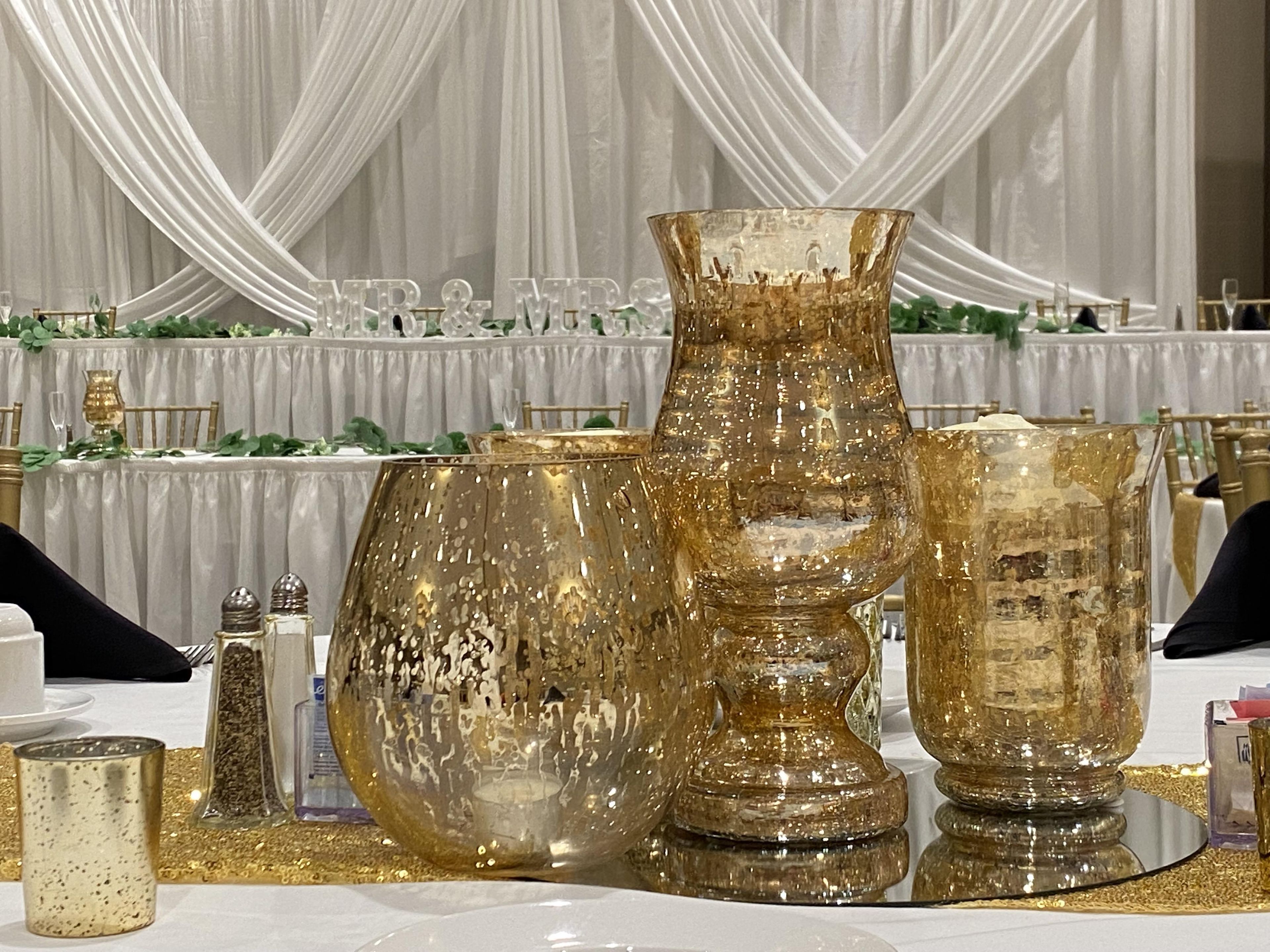 Une table dressée avec de la verrerie aux tons dorés et une nappe blanche.