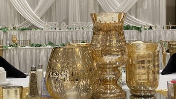 A table set with gold-toned glassware and a white tablecloth.
