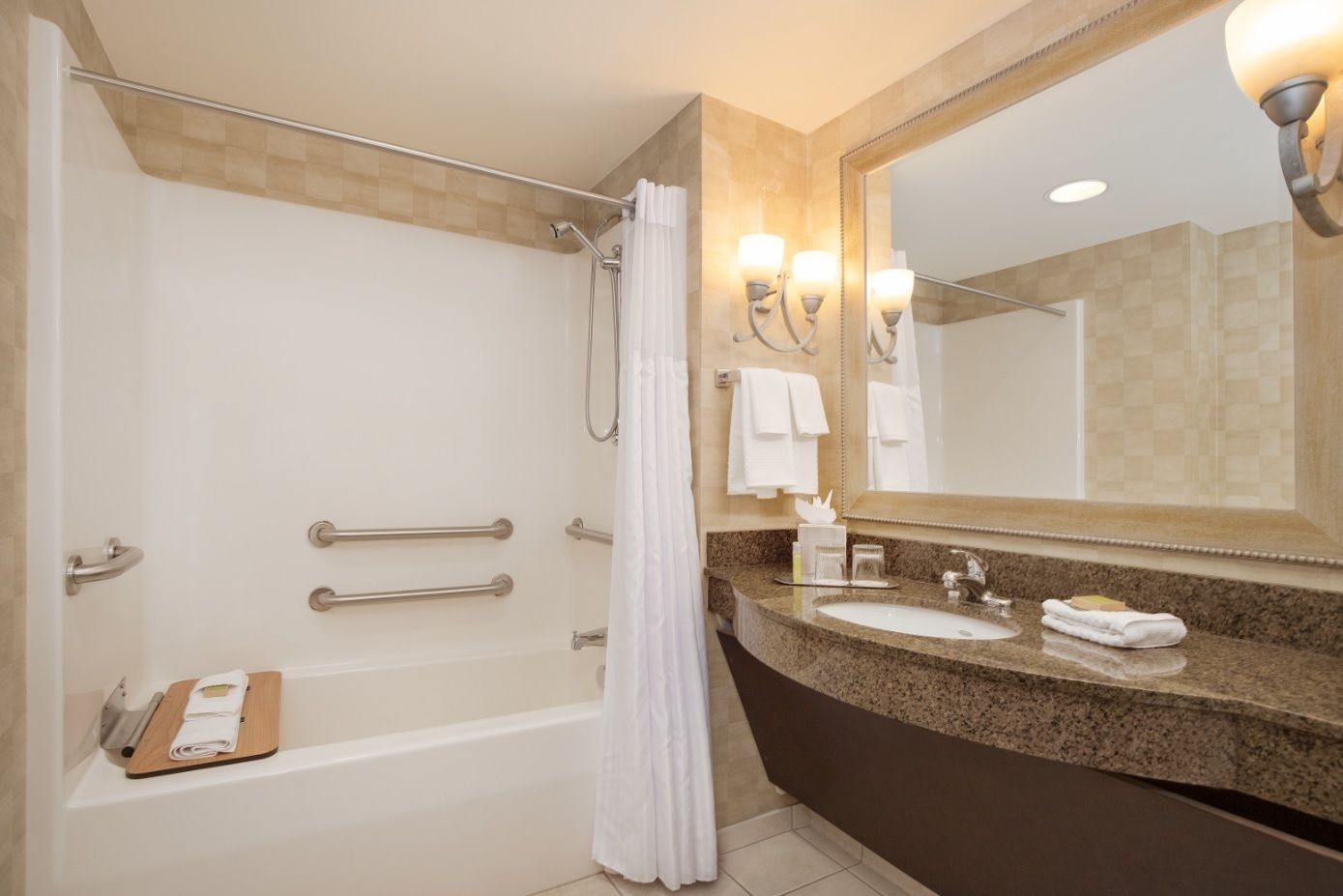 A modern bathroom with a bathtub, shower, and vanity with a sink and mirror.