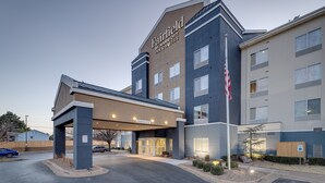 Een Fairfield by Marriott Inn & Suites gebouw met een modern design, voorzien van een overdekte ingang en een vlaggenmast.