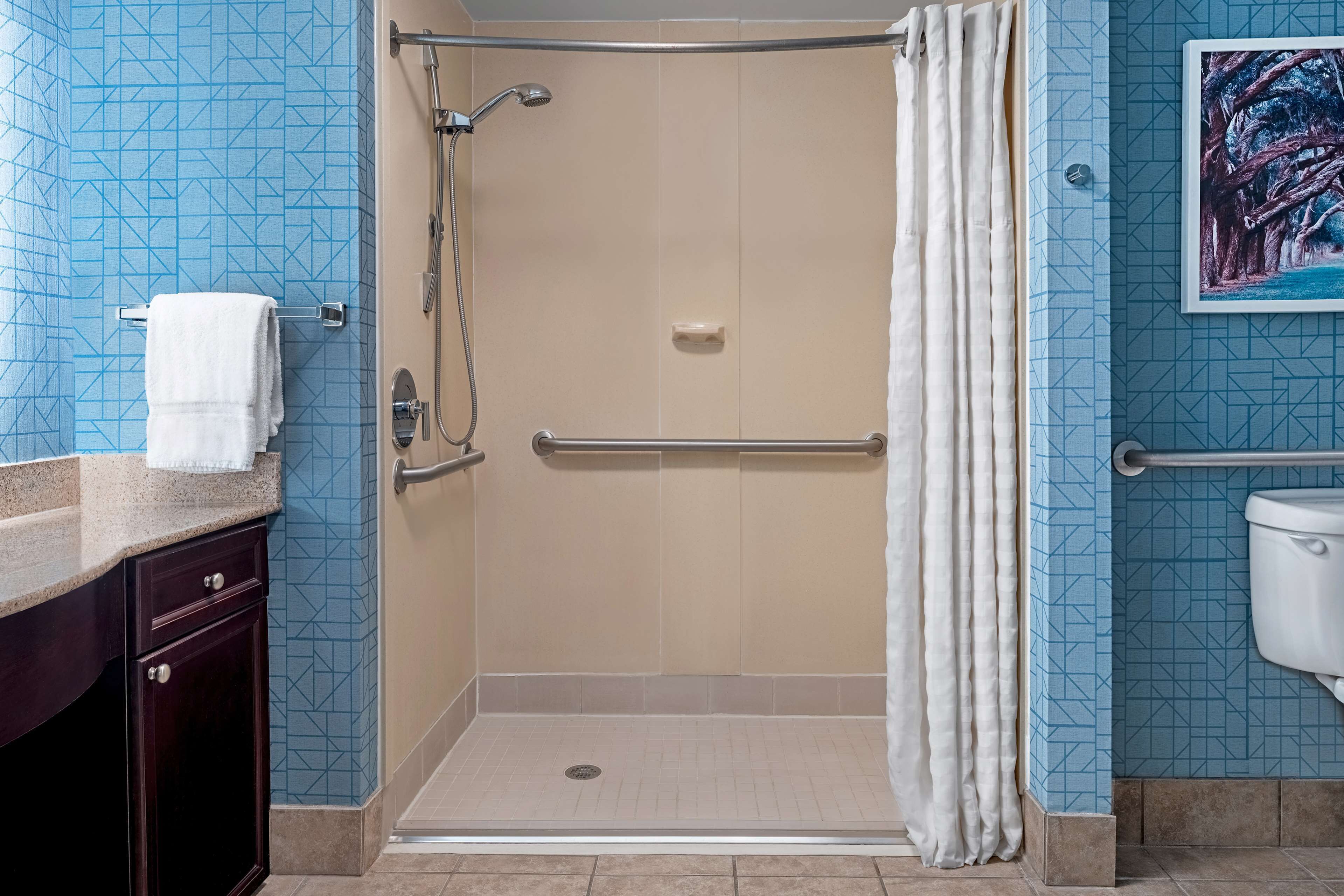Un baño con cabina de ducha, inodoro y lavamanos.