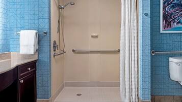 Un baño con cabina de ducha, inodoro y lavamanos.
