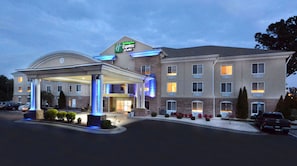 Um hotel Holiday Inn Express com entrada coberta, vários andares e estacionamento.