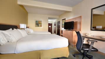 A hotel room with a large bed, a desk with a chair, a television, and a mirror.