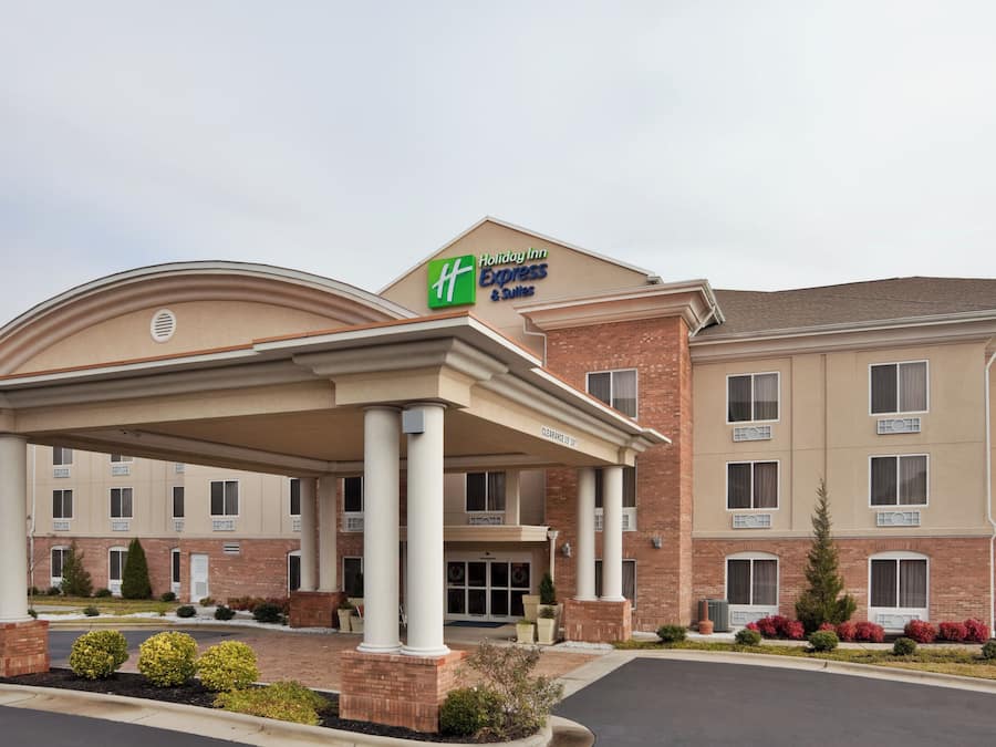 A Holiday Inn Express & Suites hotel with a covered entrance, brick facade, and multiple windows.