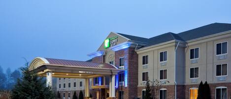 A Holiday Inn Express hotel with a covered entrance, brick facade, and a parking lot.