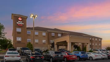A Best Western Plus hotel with a parking lot filled with various cars.