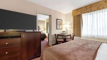 Een hotelkamer met een bed, een bureau, een dressoir en een televisie.