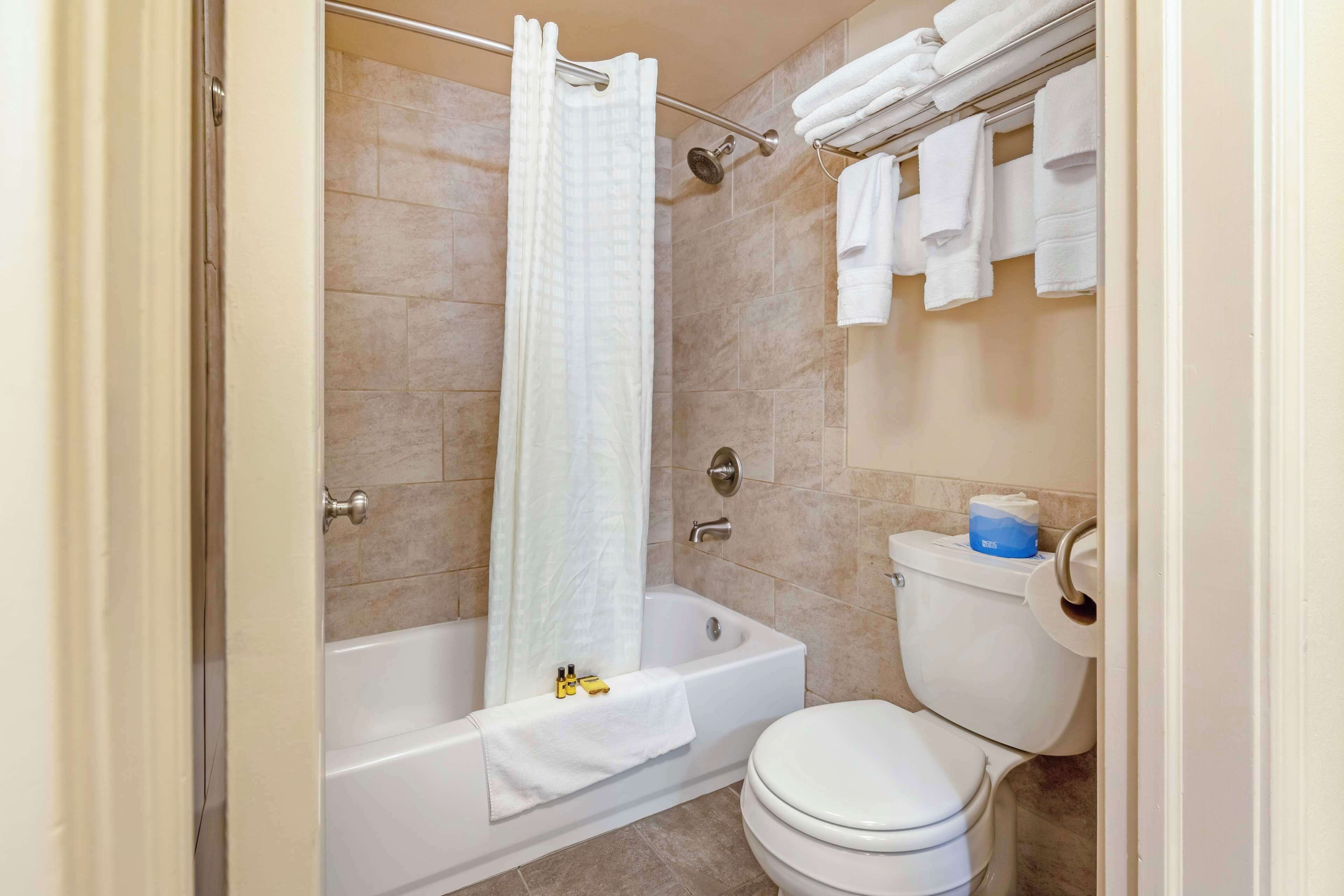 A bathroom with a bathtub, toilet, and towel rack.
