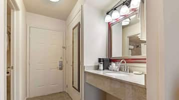 A bathroom with a sink, mirror, and towel rack.