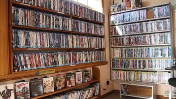 A library with multiple shelves of DVDs and books.