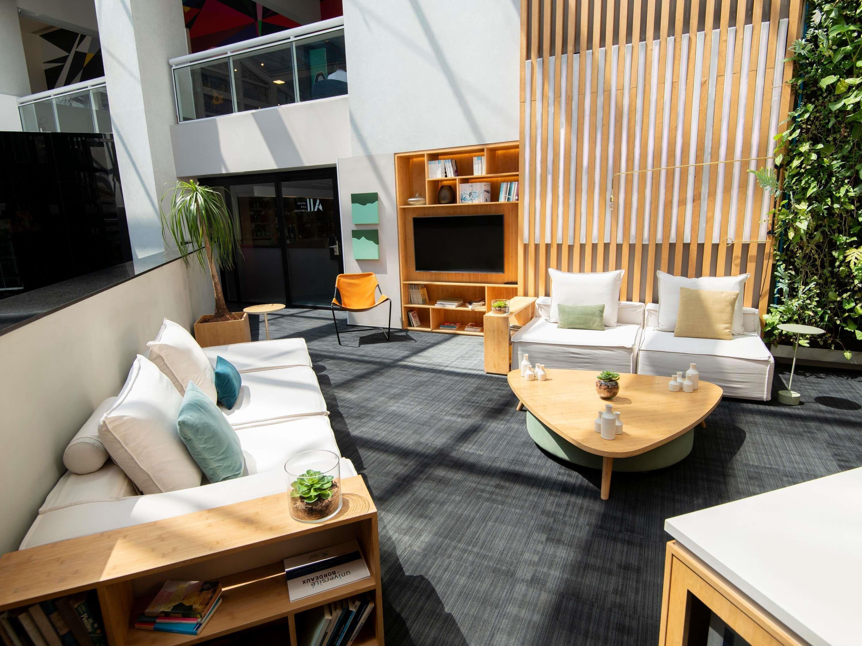 Uma área de estar moderna com um sofá, uma mesa de centro e uma estante de livros.