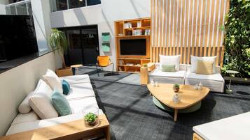 Uma área de estar moderna com um sofá, uma mesa de centro e uma estante de livros.