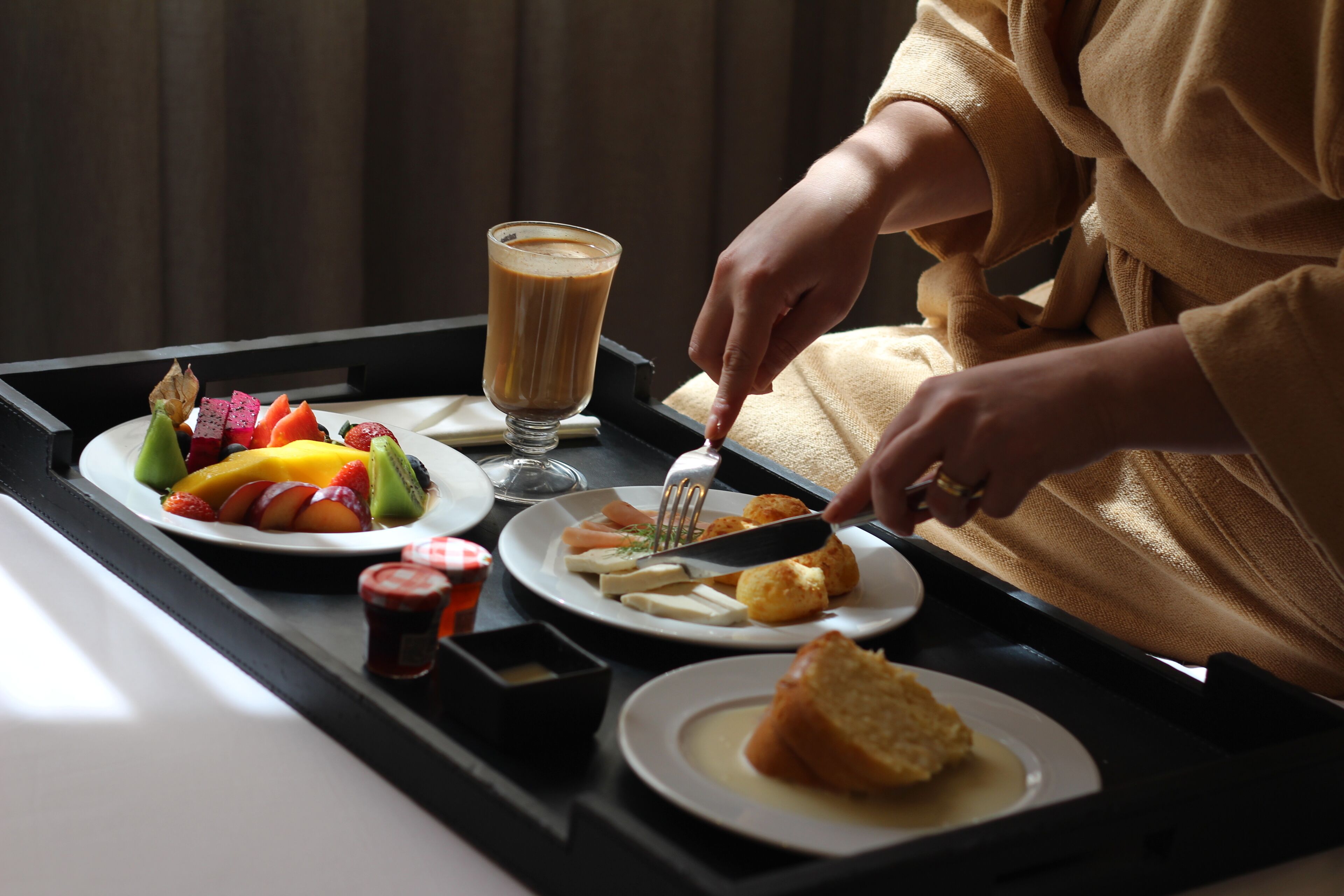A tray with breakfast items including fruit, toast, and a beverage.
