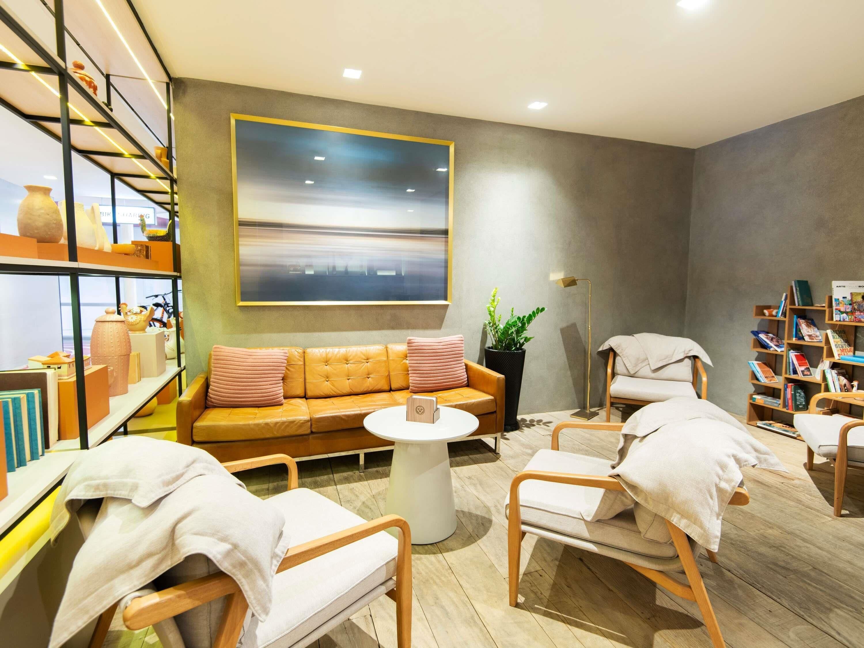 A modern living room with a sofa, chairs, a coffee table, and a bookshelf.