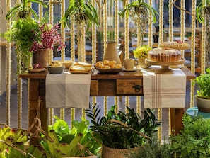 A wooden table with a checkered cloth, various food items, and hanging plants. - Grand Mercure Sao Paulo Vila Olimpia (São Paulo)