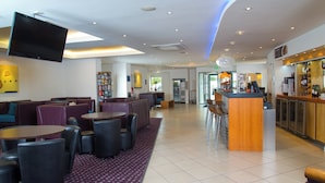 A hotel lobby with seating areas, a bar, and a television mounted on the wall. - Holiday Inn Express Bedford by IHG (Bedford)