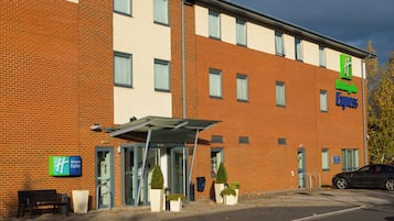 A Holiday Inn Express building with a brick facade, a covered entrance, and a parking lot.