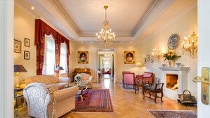 Un salón amplio con chimenea, muebles elegantes y decoración clásica.