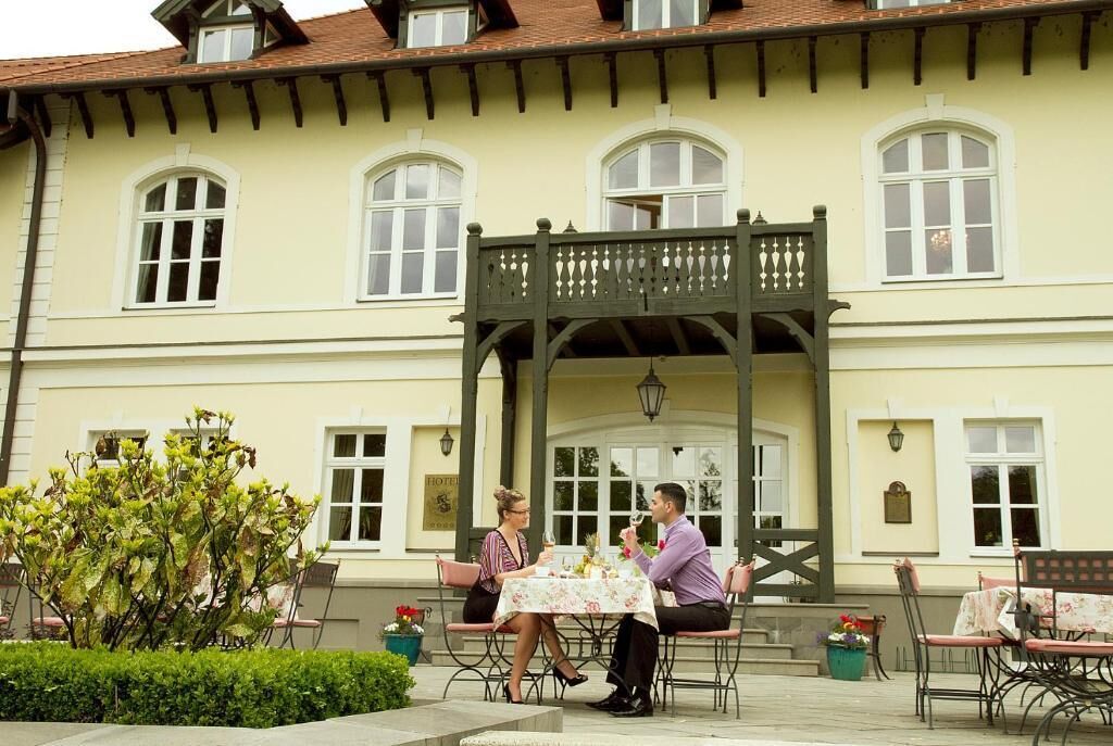 A building with a balcony and a table set for two people.