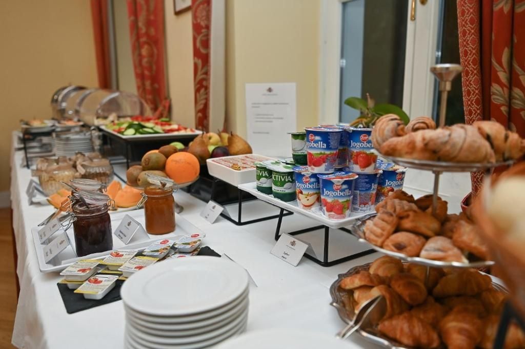 A buffet table with various food items including fruits, pastries, and dairy products.
