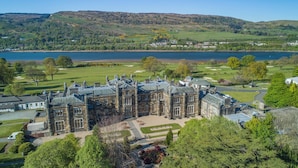 A large, historic stone building with multiple wings, surrounded by well-maintained lawns and a golf course. - JA Mar Hall Scotland (Bishopton)