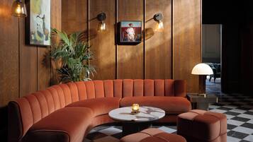 A modern lounge area with a curved sofa, a round coffee table, and a checkered floor.