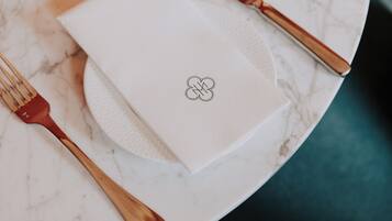 Une serviette blanche ornée d’un logo, posée sur une table en marbre.