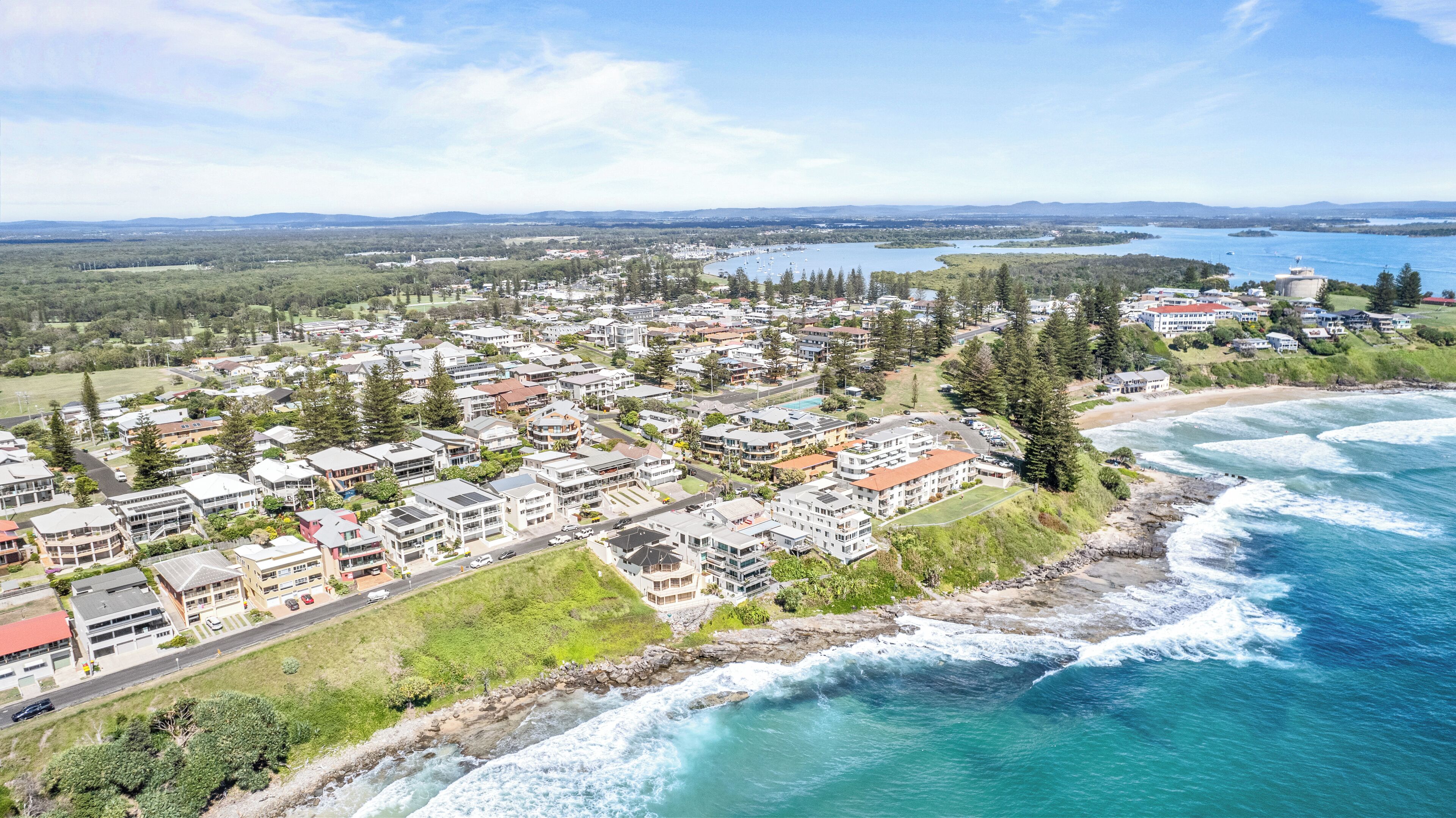 Un pueblo costero con edificios residenciales, una playa y una bahía.