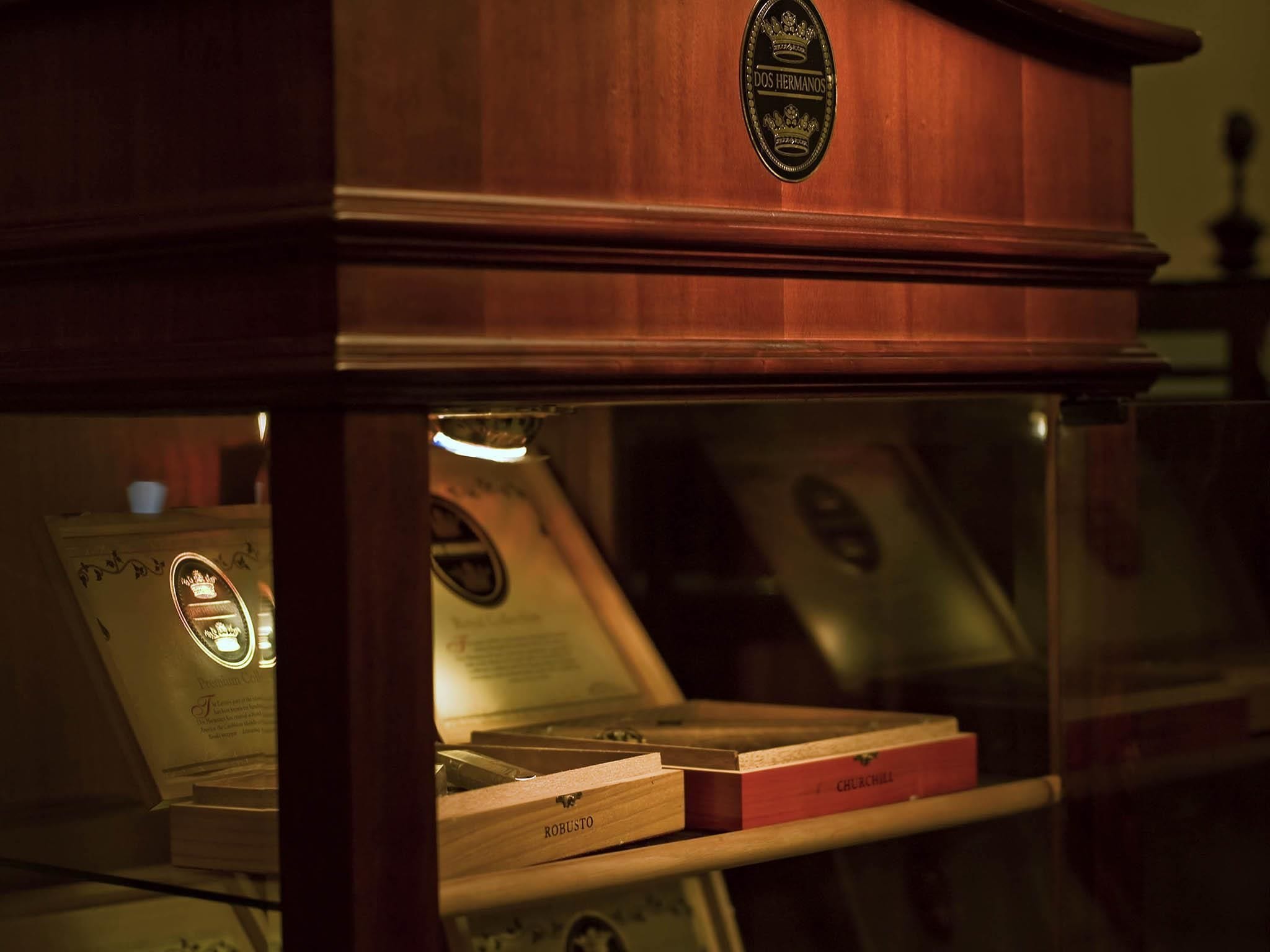 A wooden cabinet with a brass emblem and a glass display case containing books and a certificate.