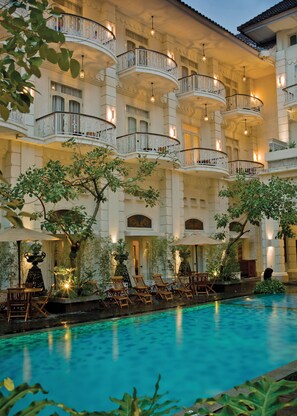 Un hôtel doté de nombreux balcons, d’une piscine et d’espaces de détente en plein air.