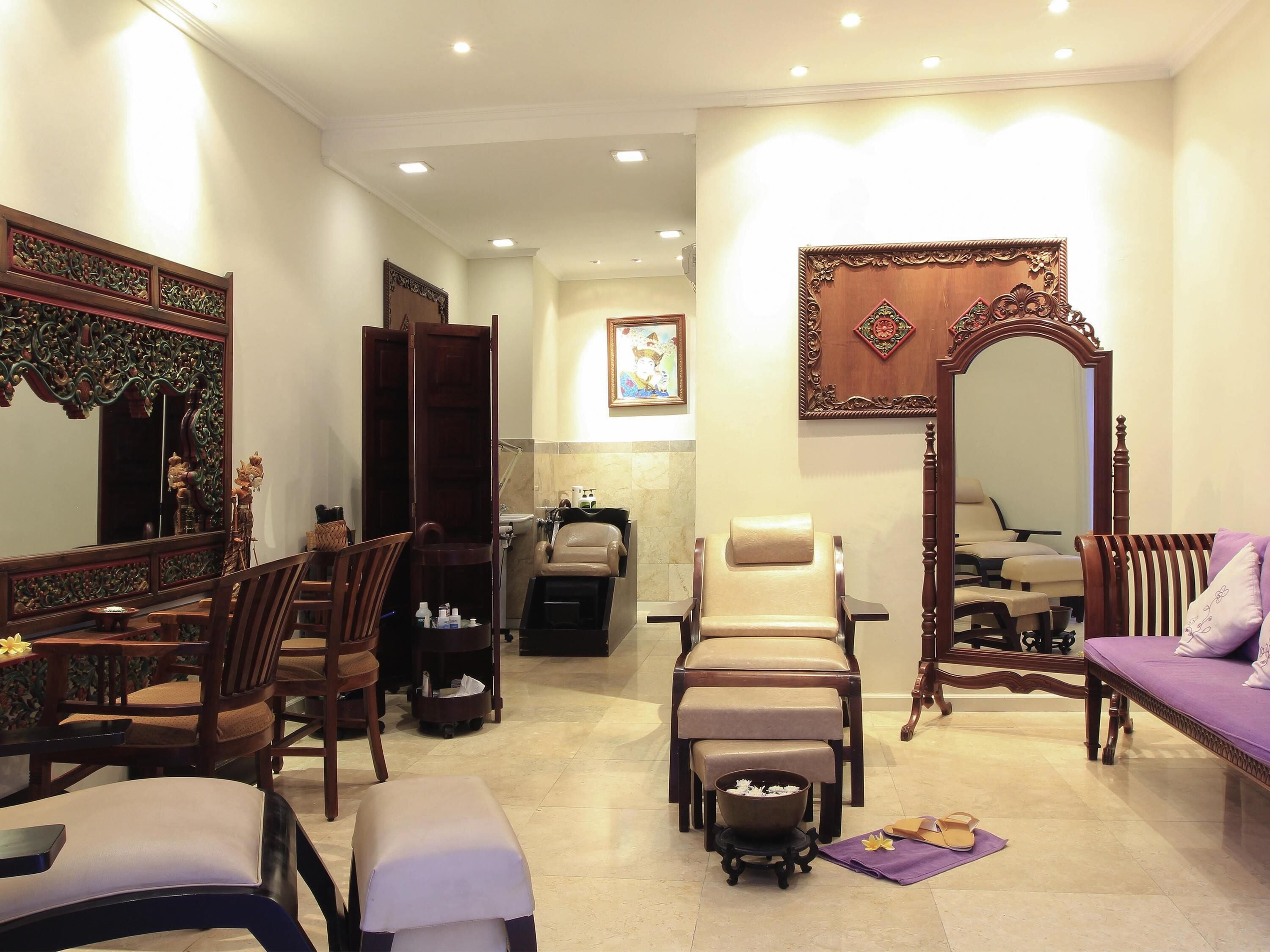 A traditional room with a sofa, chairs, a mirror, and a small table with a bowl and a candle.