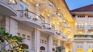 Een hotel met meerdere verdiepingen, balkons, grote ramen en een klassieke bouwstijl.