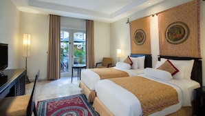Une chambre d’hôtel avec deux lits, une télévision, un bureau et une vue sur l’extérieur.