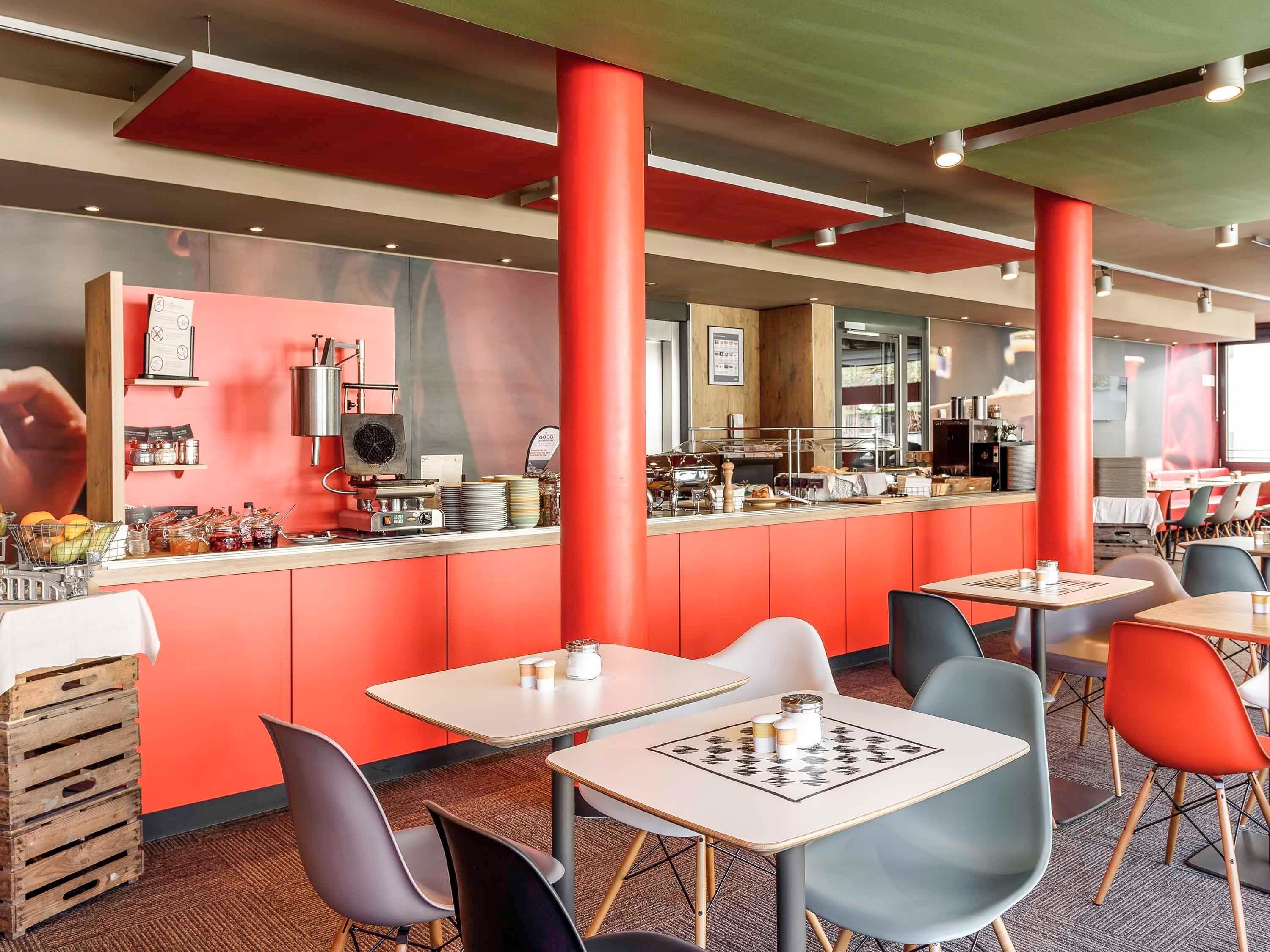 Un caffè moderno con tocchi rossi, un bancone per il caffè e zone con posti a sedere.