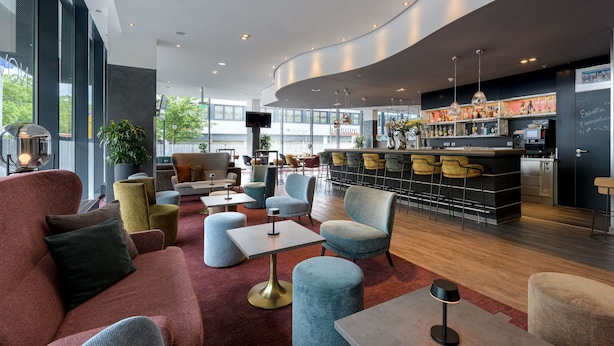 Un'area lounge moderna con comodi posti a sedere, un bar e una macchina del caffè.
