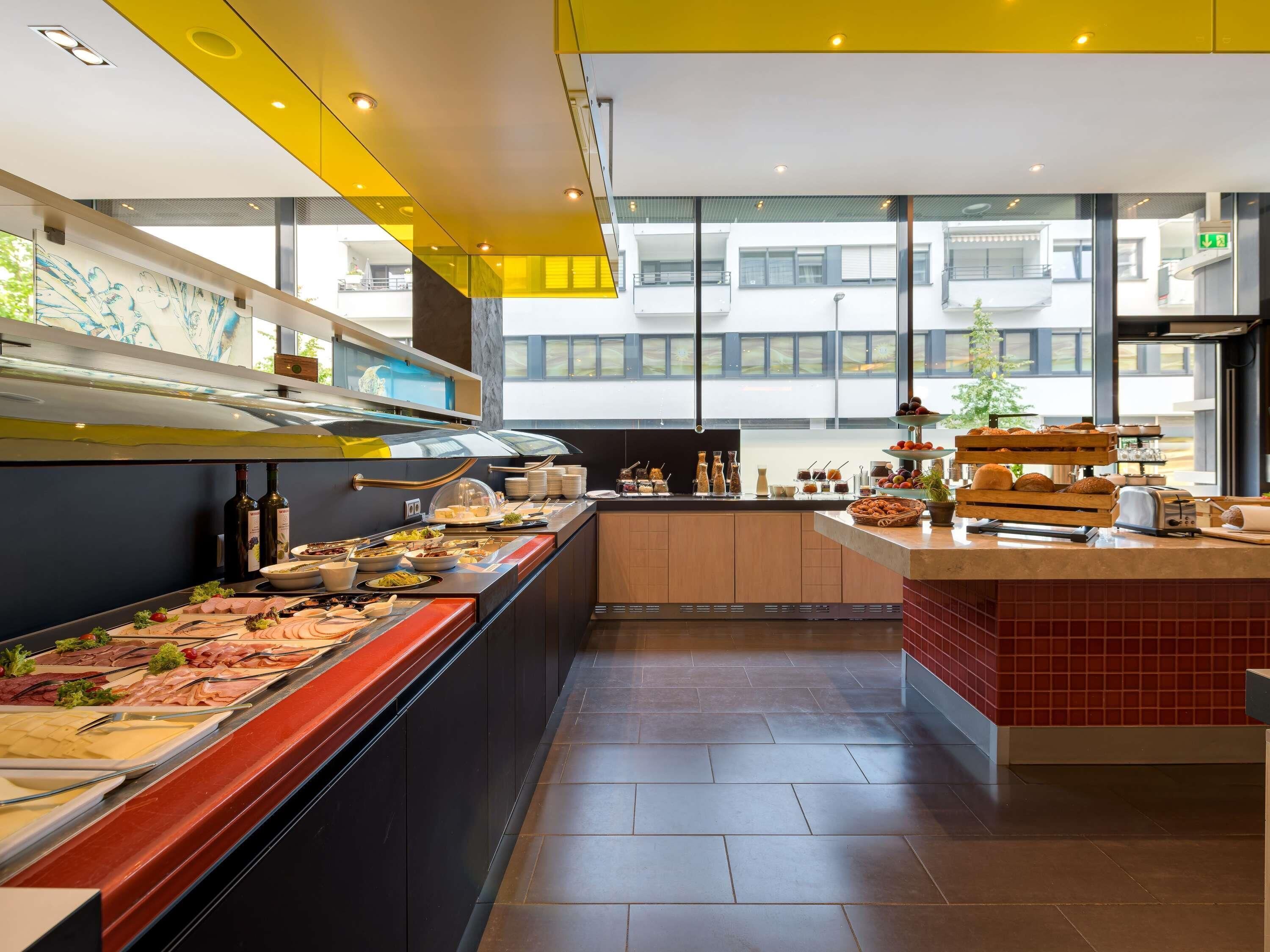 A modern kitchen with a buffet setup, including a variety of food items and a coffee station.