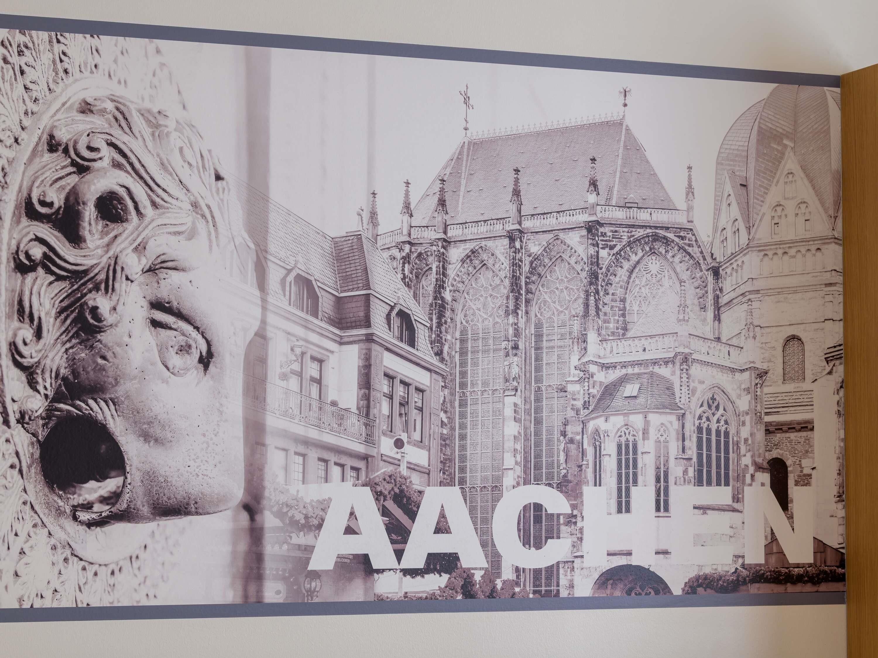 A poster with a gothic building and the text "AACHEN".
