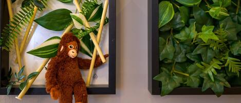 A framed picture with a plush toy and artificial plants.